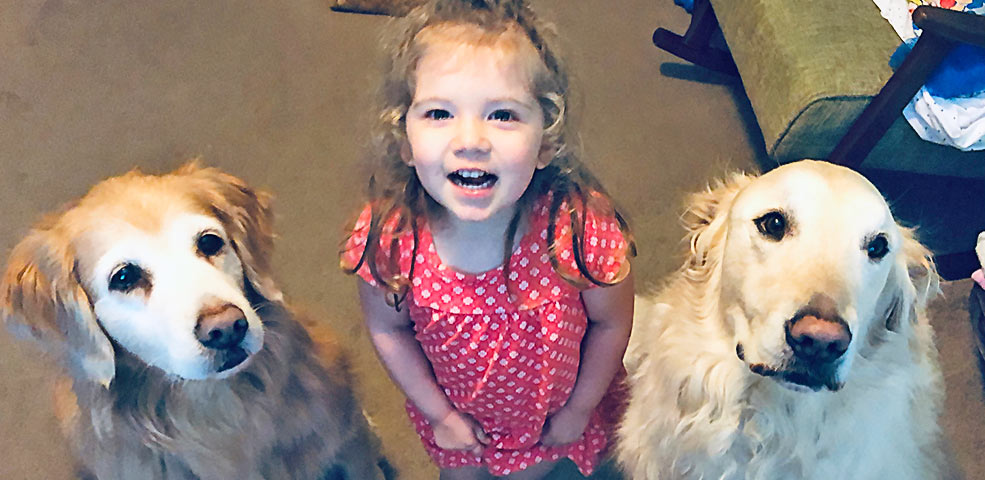 Blog Feature photo for Coffee Tails. Featuring Colt Austin, and his two love-able pups: Marley and Zeus. Two golden retrievers sitting politely with Colt's daughter Opal.
