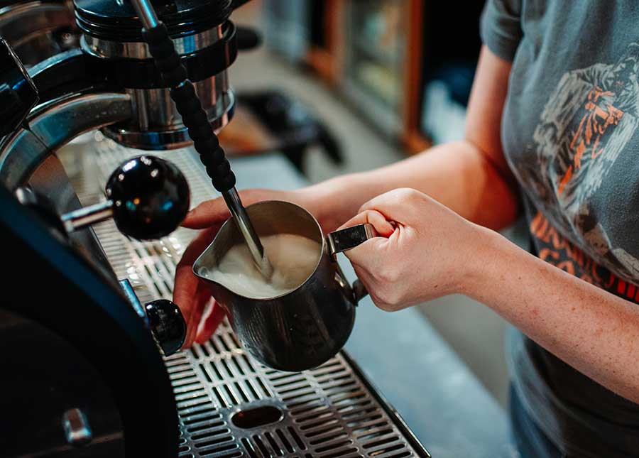 Amavida barista steaming milk on La Marzocco espresso machine.